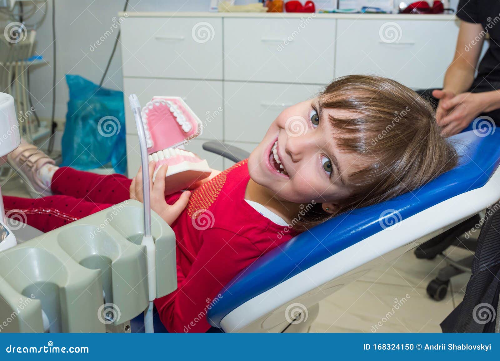 a happy girl with a jaw mock in a dentistÃ¢â¬â¢s office